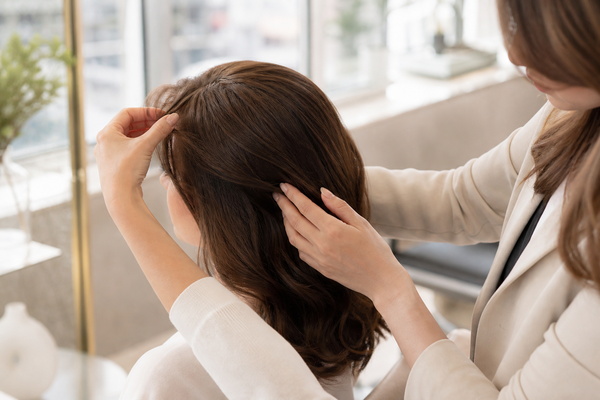 stylist blending natural hair over a finished hair topper edge