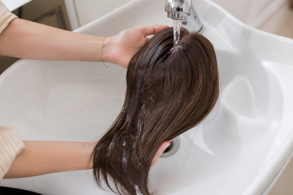 washing a human hair topper under cool water